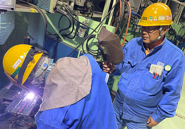 技術訓練所にて溶接を指導する川嶋（右）