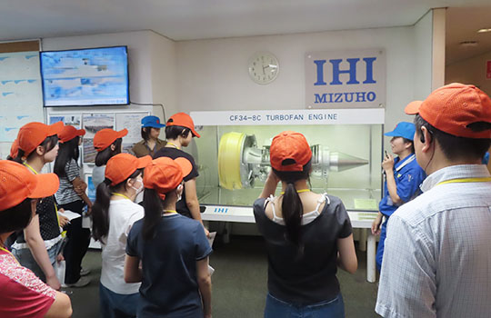 Students listening attentively to an explanation of how aircraft engines work