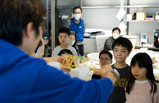 橋が重さに耐えられるかの実験の様子を見守る子どもたち